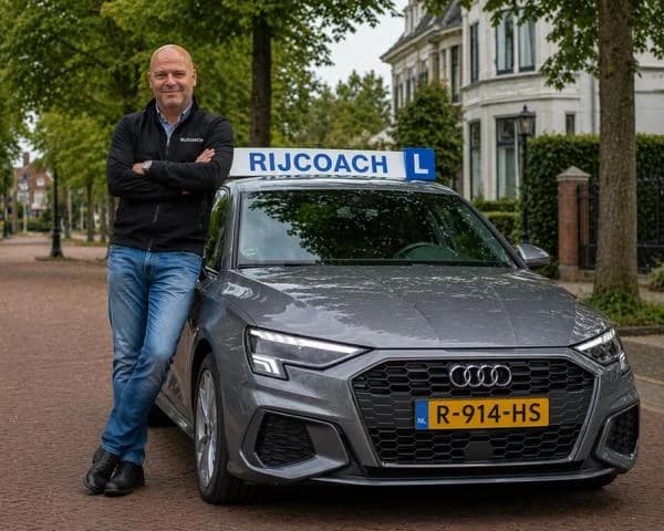 Rob Nijdam van Rijschool Rijcoach bij de grijze RIJCOACH lesauto in Haarlem
